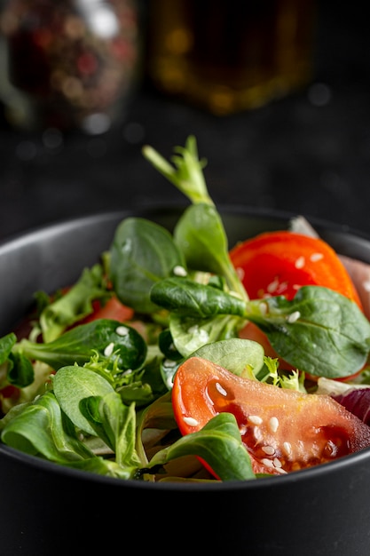 Frischer Salat in der dunklen Schüssel Nahaufnahme