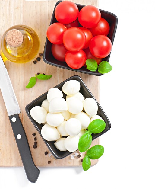 Frischer Salat mit Kirschtomaten, Basilikum, Mozzarella und schwarzen Oliven.