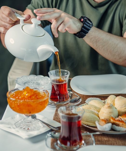 Kostenloses Foto frischer schwarzer tee mit marmelade auf dem tisch