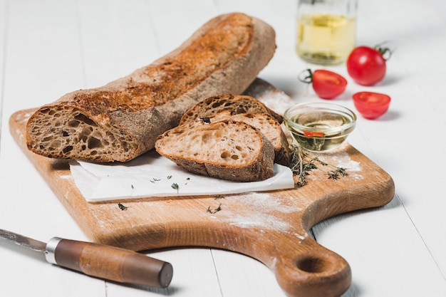 Frisches Brot mit Messer auf Schneidebrett