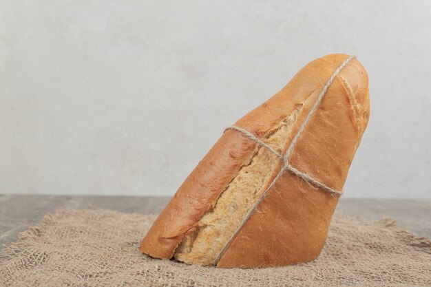 Frisches Brot mit Seil auf Sackleinen gebunden. Hochwertiges Foto