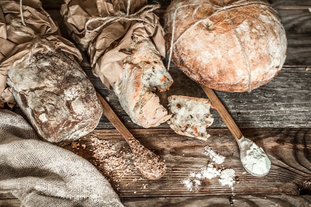 frisches Brot und Holzlöffel auf altem hölzernem Hintergrund