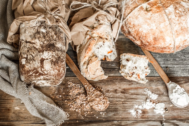 frisches Brot und Holzlöffel auf altem hölzernem Hintergrund