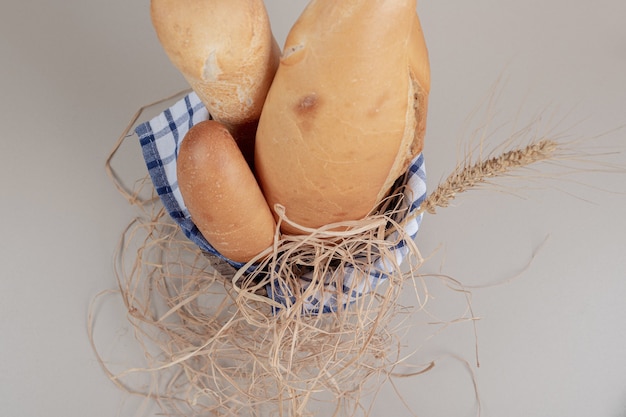 Frisches Gebäck des Brotes auf Holzkorb mit Tischdecke