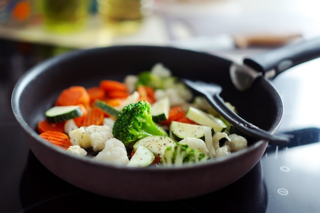 Frisches gemüse, das zu hause auf pfanne kocht. nahansicht.