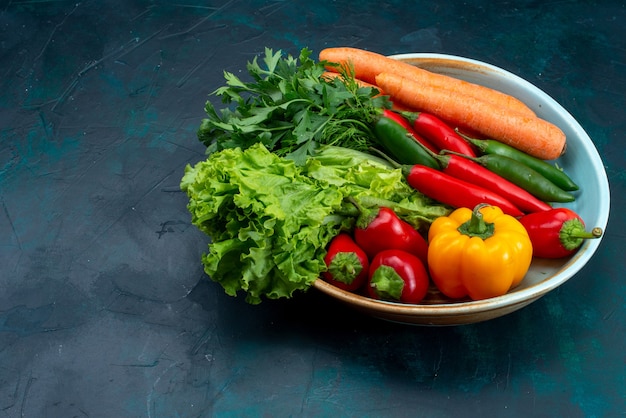 Frisches Gemüse der Vorderansicht mit Grün auf blauem Schreibtischsnacksalatgemüselebensmittel