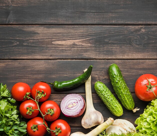 Frisches Gemüse für Salat auf hölzernem Hintergrund