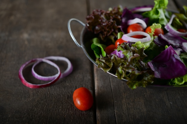 Kostenloses Foto frisches gemüse salat in der schüssel mit rustikalen alten hölzernen hintergrund.