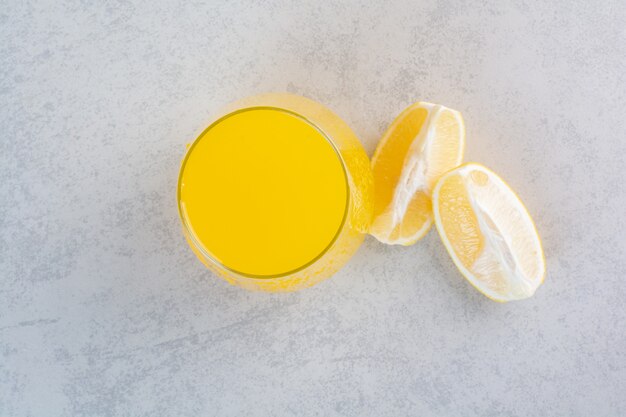 Frisches Glas Limonade mit geschnittener Zitrone auf grau.