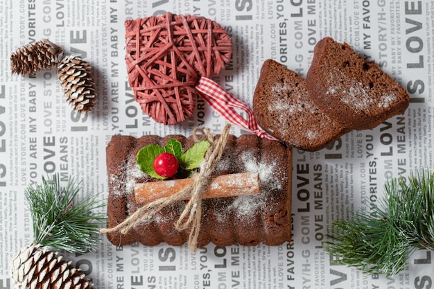 Frisches hausgemachtes schokoladenroulette auf papier mit weihnachtsschmuck.