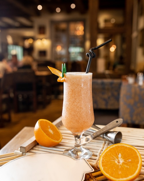 Frisches orange Cocktail auf dem Tisch mit Orangen