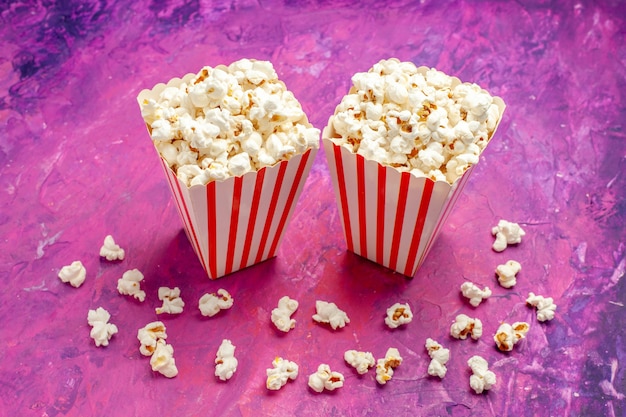 Frisches Popcorn der Vorderansicht auf hellrosa Tischfarbkino-Film