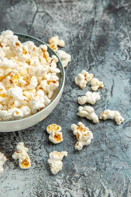 Frisches Popcorn der Vorderansicht für Film auf dem hellen Hintergrund