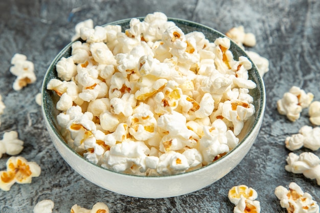 Frisches Popcorn der Vorderansicht für Film auf dem hellen Hintergrund