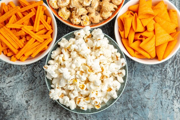 Frisches Popcorn von oben mit Zwieback und Cips auf leichtem Schreibtisch