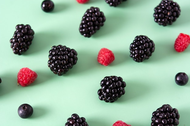 Frisches Sortiment Beeren auf grünem Hintergrund