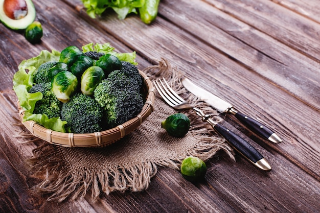 Frisches und gesundes Essen. Holzschale mit Brokkoli, Rosenkohl, Olivenöl, grünem Pfeffer