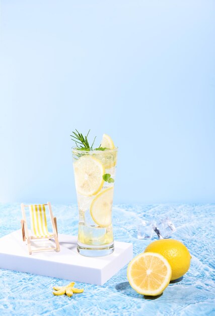 frisches Zitronenwasser in einem Glas mit Zitronenscheiben Früchte am Meerstrand mit Sommer Seeurlaub und Reisen