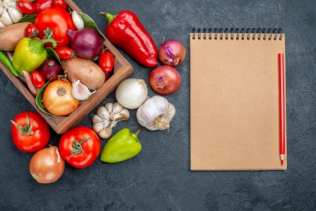 Frischgemüsezusammensetzung der draufsicht auf reifem frischem farbsalat des dunklen bodens