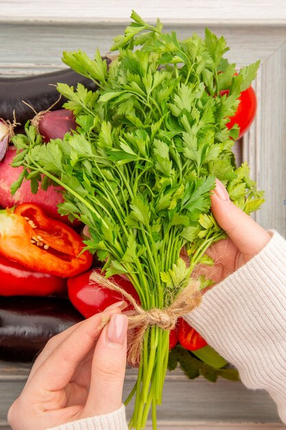 Frischgemüsezusammensetzung der Draufsicht mit Grüns innerhalb des Rahmens auf weißem Tisch