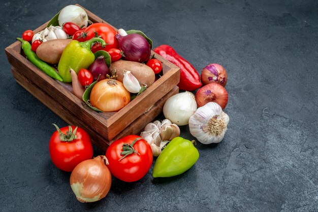 Frischgemüsezusammensetzung der Vorderansicht auf reifem frischem Farbsalat des dunklen Tisches