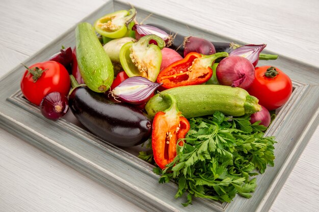 Frischgemüsezusammensetzung der Vorderansicht mit Grüns auf weißem Salat gesundes Lebenmahlzeit reifes Gemüsefotofarbe