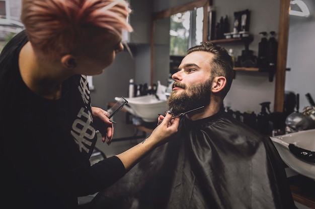 Kostenloses Foto friseur, der bart des kunden schneidet