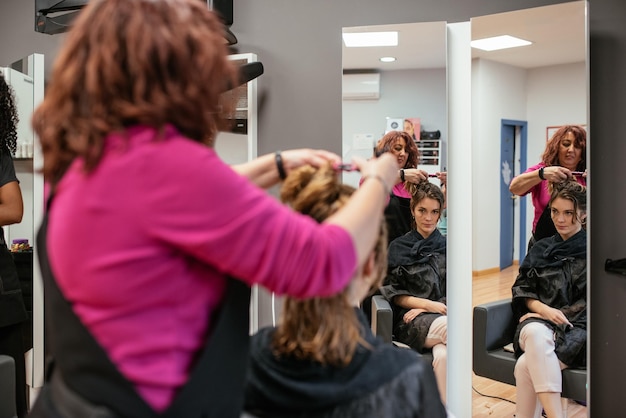 Friseur, der das Haar der Frau trocknet