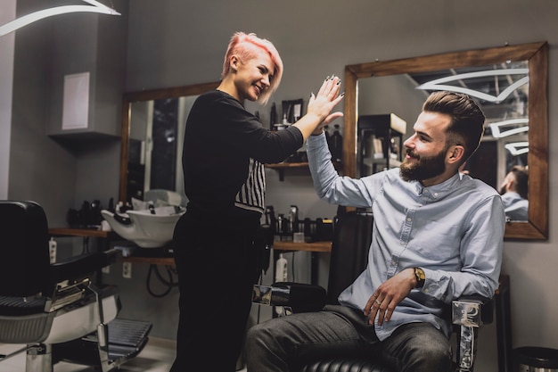 Friseur, der dem Kunden hohe fünf gibt