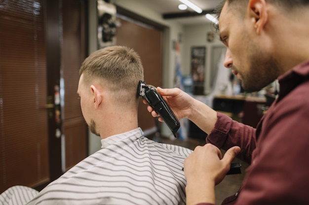 Friseur, der einem Kunden einen Haarschnitt gibt