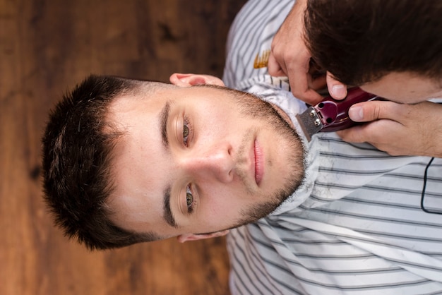 Friseur, der einen mannbart mit scherer trimmt