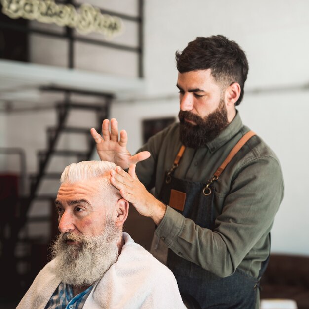 Friseur, der Kundenhaar für Haarschnitt vorbereitet