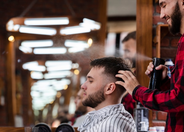 Friseur, der Kundenhaar sprüht