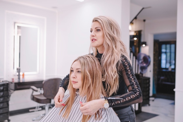 Friseur, der mit Kunden herein während der Arbeit spricht