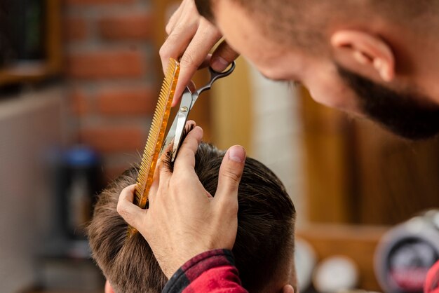 Friseur, der mit Scheren und Kamm trimmt