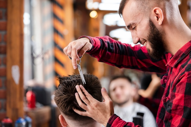 Kostenloses Foto friseur, der scheren verwendet, um eine frisur zu machen