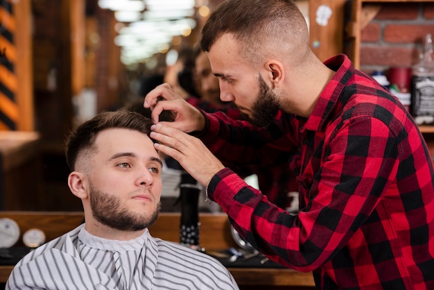 Friseur, der um Haar eines Kunden sich kümmert