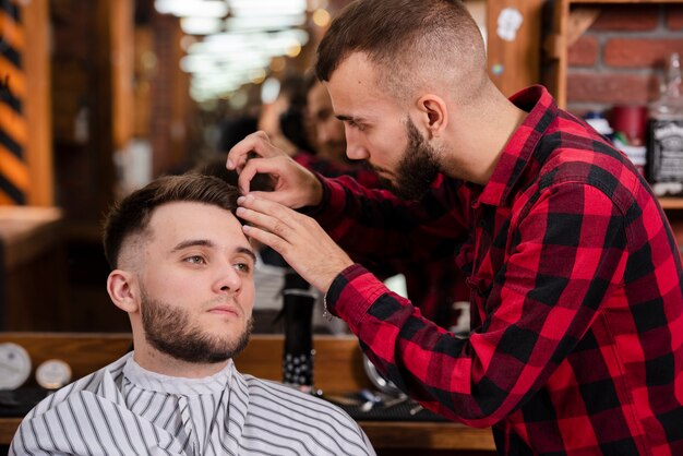 Friseur, der um Haar eines Kunden sich kümmert