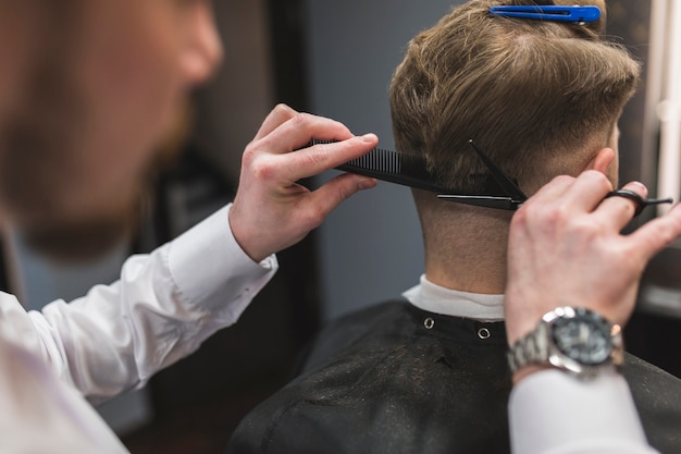 Friseur Haare schneiden am Hals des Kunden