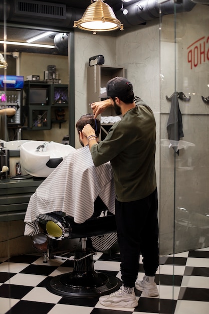 Friseur schneidet einem Mann die Haare im Friseurladen