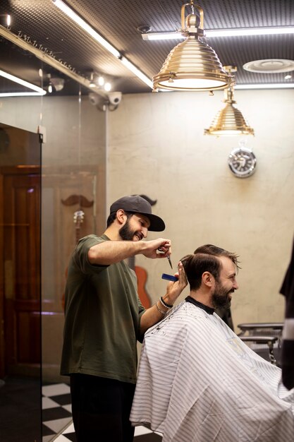 Friseur schneidet einem Mann die Haare im Friseurladen