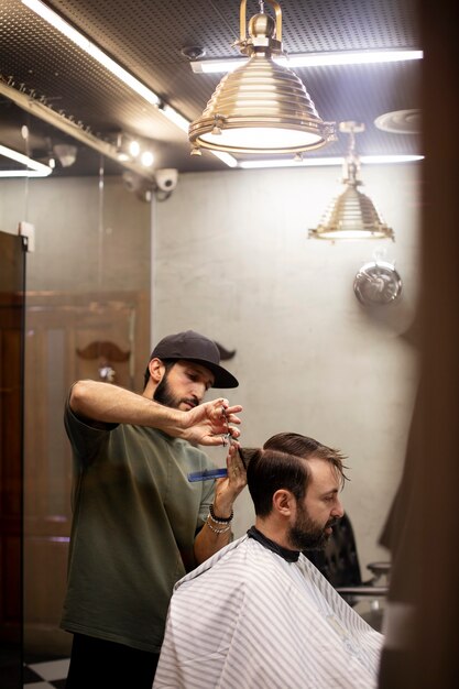 Friseur schneidet einem Mann die Haare im Friseurladen