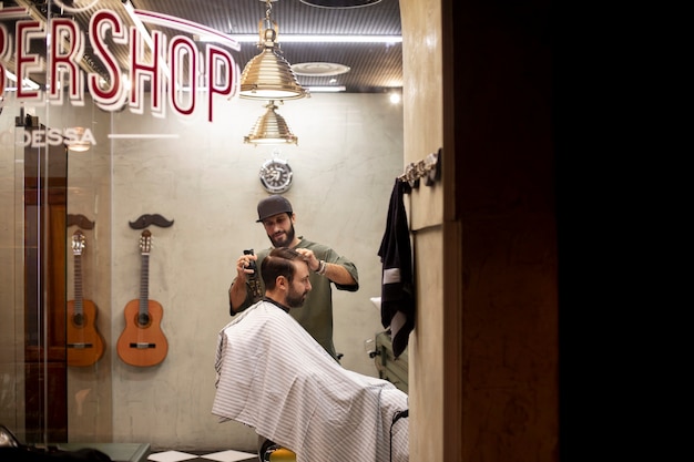 Friseur schneidet einem Mann die Haare im Friseurladen