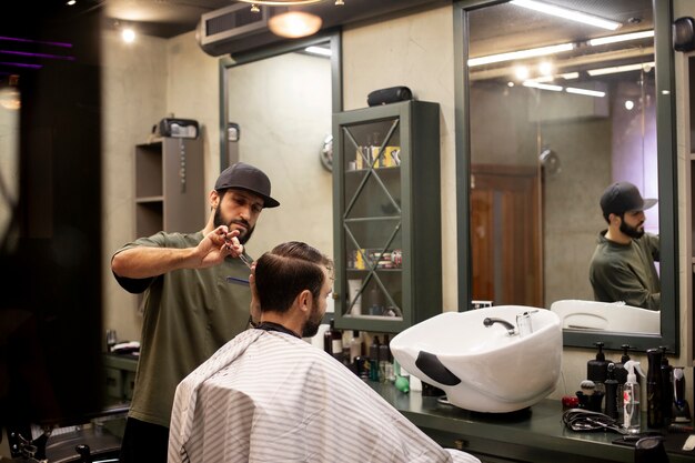 Friseur schneidet einem Mann die Haare im Friseurladen