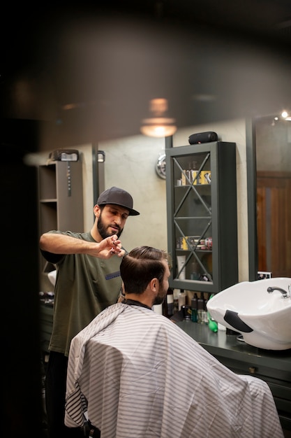 Kostenloses Foto friseur schneidet einem mann die haare im friseurladen