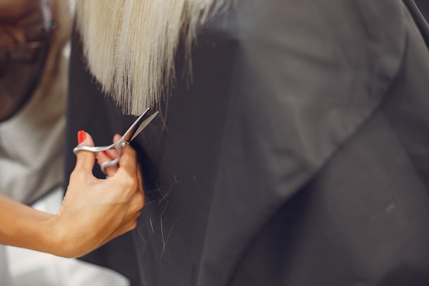 Friseur schnitt Haar ihr Klient in einem Friseursalon