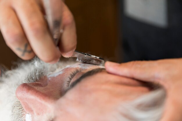 Friseurausschnittbart mit Rasiermesser zum Kunden