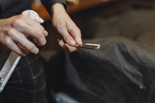 Friseursalon. Nahaufnahme des Friseurs hält Rasiermesser für das Rasieren seines Bartes