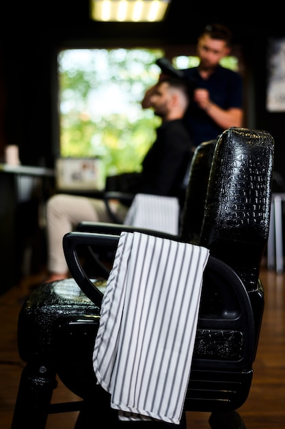 Friseursalonstuhl mit Tuch auf Lehnsessel