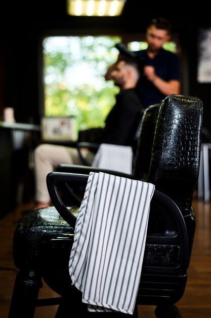 Friseursalonstuhl mit Tuch auf Lehnsessel